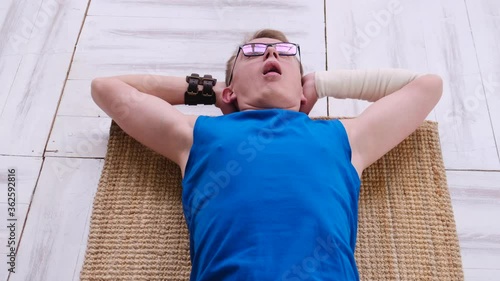 Funny nerd panting while exercising at home on the floor