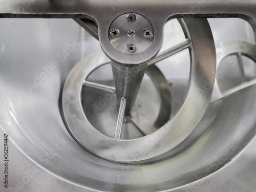 Closeup of an industrial mixer screw.Horizontal ribbon-screw stirrer for mixing farm raw materials,semi-finished products,minced meat.mixing very viscous liquids and homogeneous pasty materials