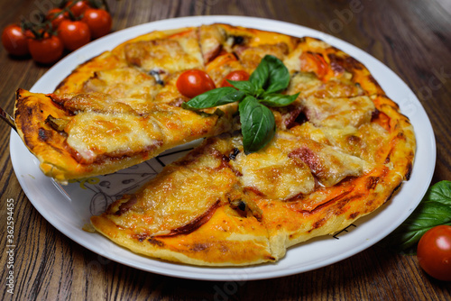 
pizza with meat and tomatoes under cheese