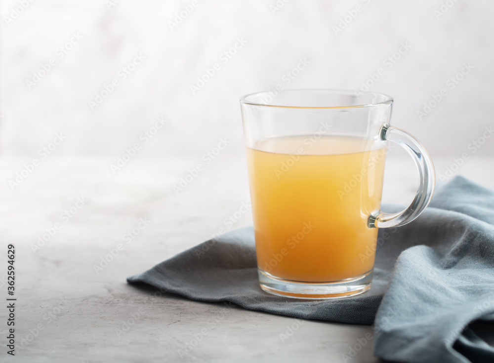 Homemade Beef Bone Broth in Glasses on a gray concrete background Homemade Beef Bone Broth in Glasses on a gray concrete background