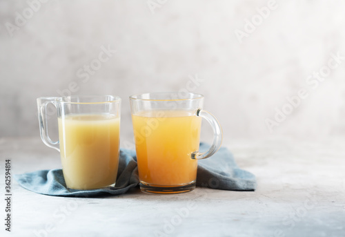 Glasses with Homemade Beef Bone Broth on a gray background with copy space