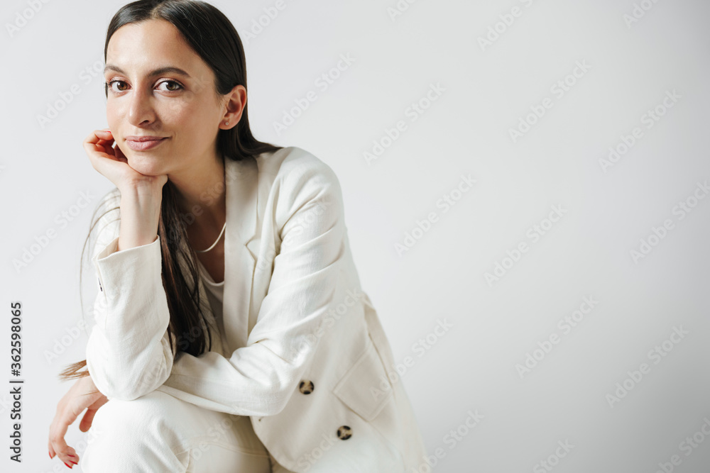 Photo of pleased businesswoman in jacket posing and looking at camera Photo of pleased businesswoman in jacket posing and looking at camera