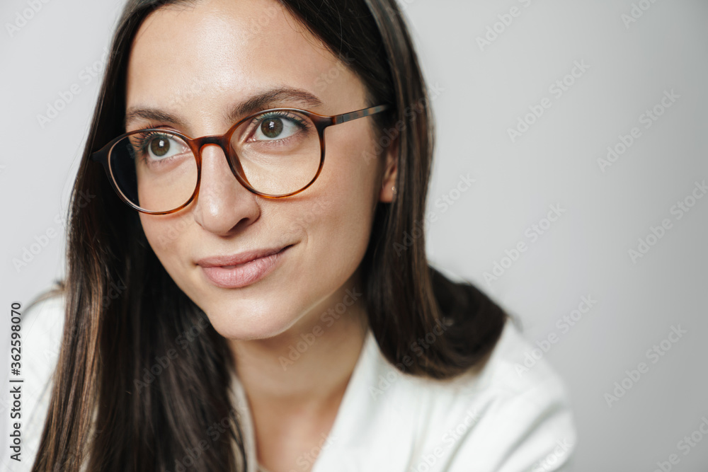 Photo of pleased businesswoman in eyeglasses posing and looking aside