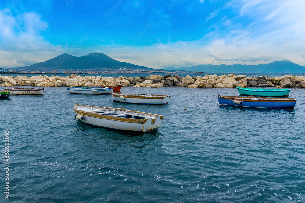 A view across the breakwater in the marina in Naples, Italy towards Mount Vesuvius in the distance