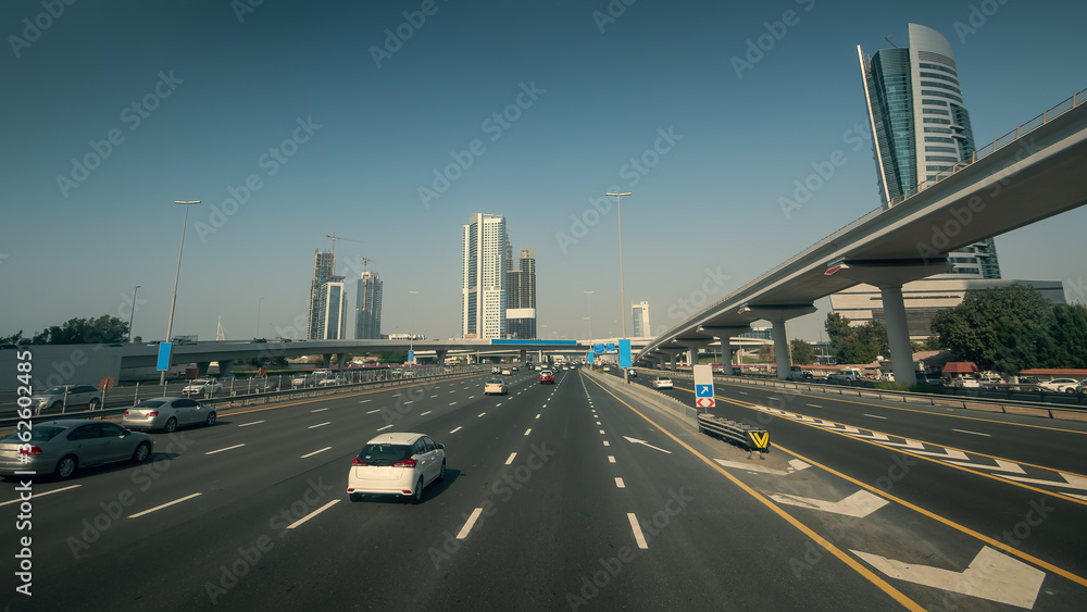 Naklejka premium Sheikh Zayed Road in Dubai with car traffic in sunny day, United Arab Emirates.