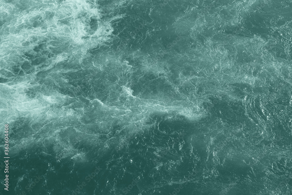 The raging waters of the river Ganges in Rishikesh. Top view of the raging elements. White foam on blue water. The raging waters of the river Ganges in Rishikesh. Top view of the raging elements. White foam on blue water.