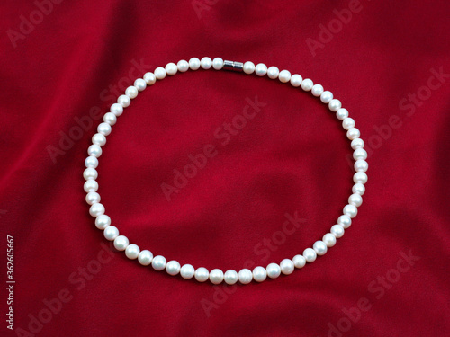 Pearl necklace on silk texture satin velvet material