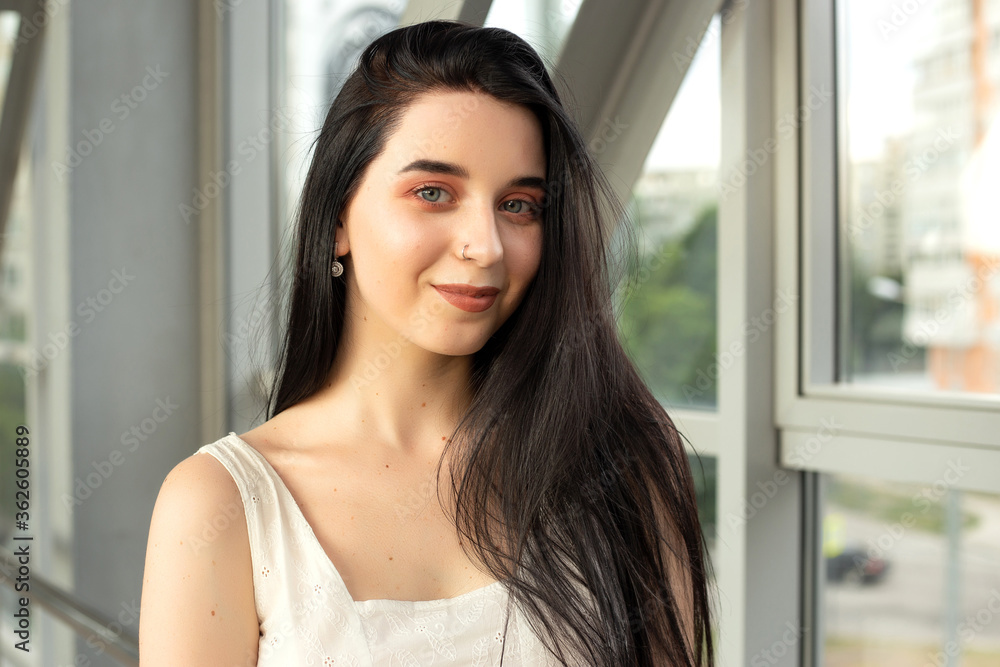 Portrait of a beautiful brunette in a light dress on the street in a pedestrian crossing on a summer day Portrait of a beautiful brunette in a light dress on the street in a pedestrian crossing on a summer day