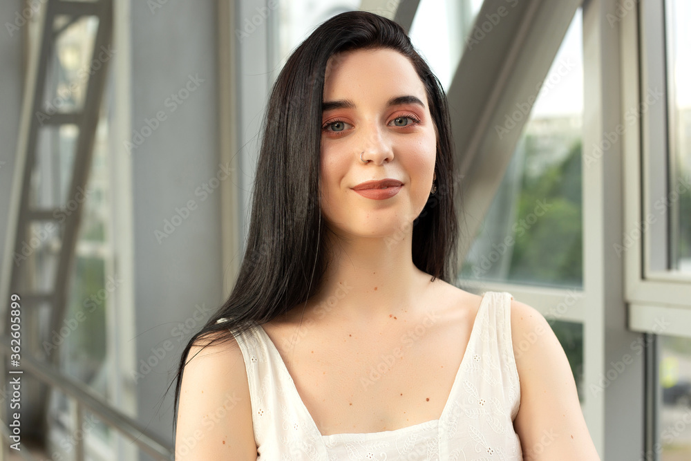 Portrait of a beautiful brunette in a light dress on the street in a pedestrian crossing on a summer day Portrait of a beautiful brunette in a light dress on the street in a pedestrian crossing on a summer day