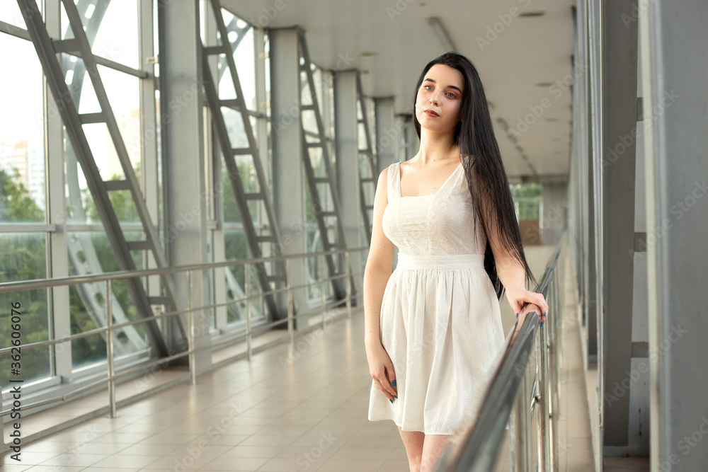 Portrait of a beautiful brunette in a light dress on the street in a pedestrian crossing on a summer day Portrait of a beautiful brunette in a light dress on the street in a pedestrian crossing on a summer day