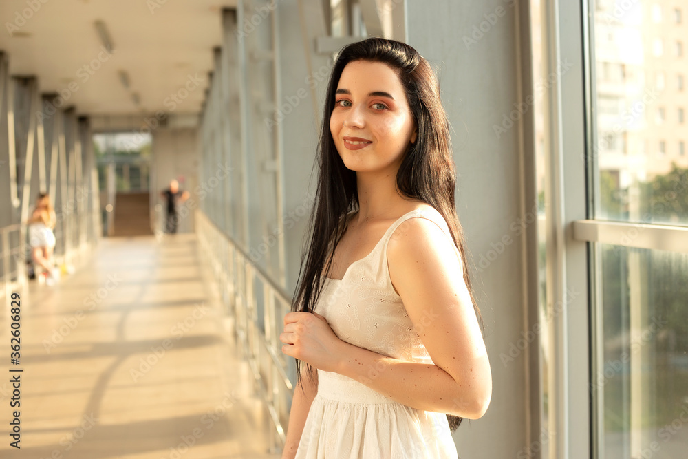 Portrait of a beautiful brunette in a light dress on the street in a pedestrian crossing on a summer day Portrait of a beautiful brunette in a light dress on the street in a pedestrian crossing on a summer day