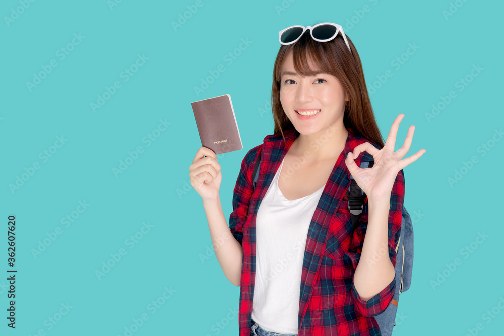 Beautiful portrait young asian woman wear sunglasses on head and backpack smiling gesture ok enjoy summer travel holiday isolated blue background, asia girl fashion trip and holding passport. Beautiful portrait young asian woman wear sunglasses on head and backpack smiling gesture ok enjoy summer travel holiday isolated blue background, asia girl fashion trip and holding passport.