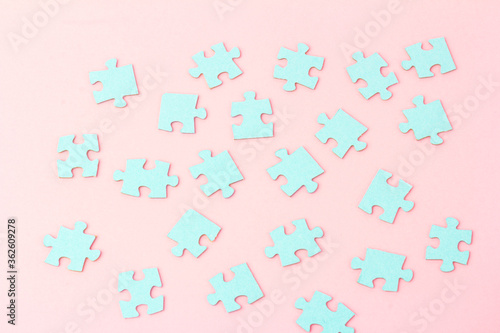 Blue puzzle pieces with empty space for your text and design on pink background.