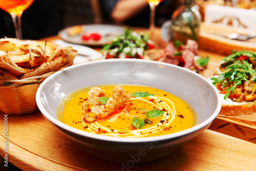 Deep plate with pumpkin soup, Italian restaurant, toned