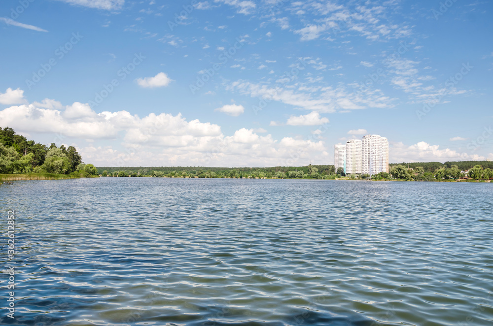 A beautiful view of the lake in the city of Kiev with a modern skyscraper and a beautiful lake. The view from the shore. Ukraine, Kiev.