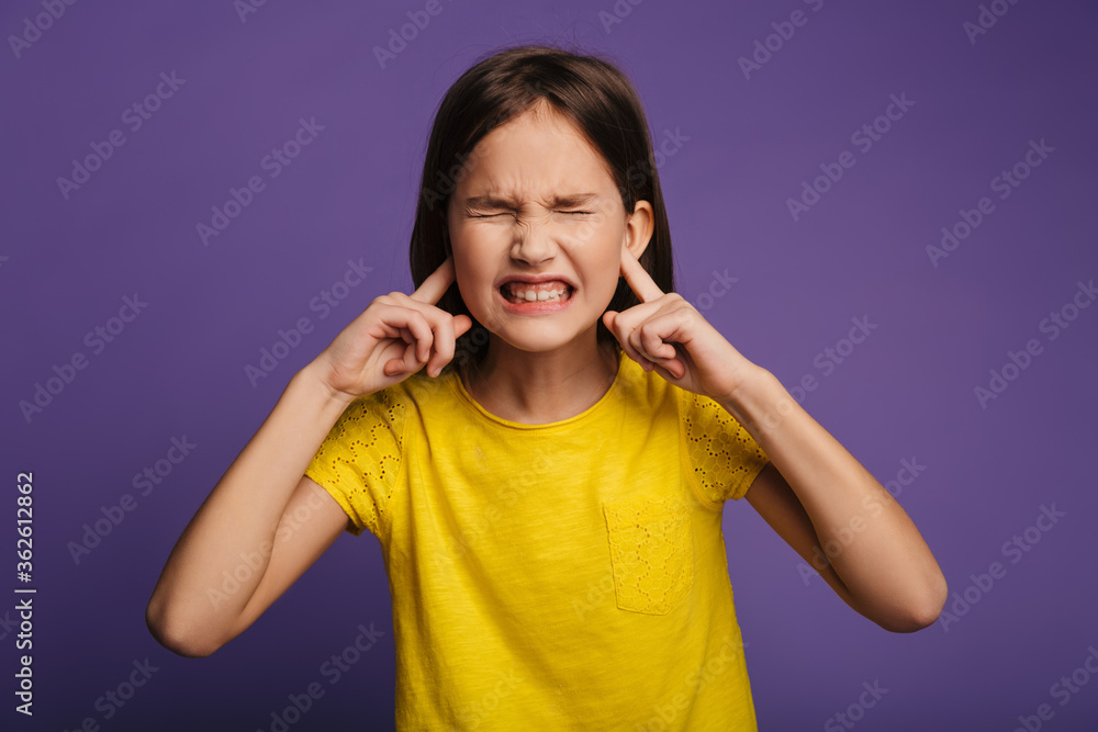 Photo of annoyed pretty girl grimacing and plugging her ears Photo of annoyed pretty girl grimacing and plugging her ears
