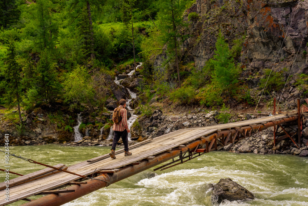 Old suspension bridge over a mountain river. Chuya, Altai