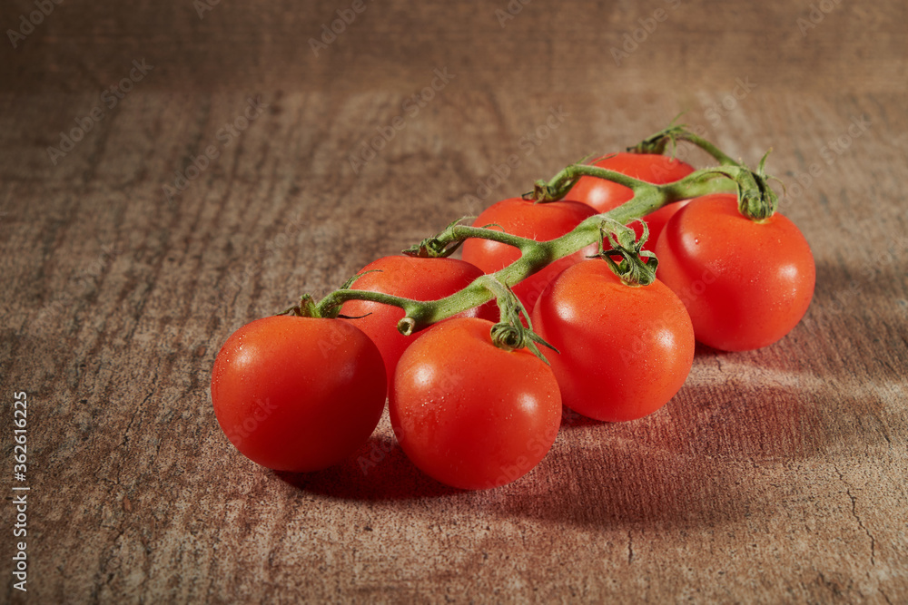 Tomato branch isolated on a wooden background. Tomato branch isolated on a wooden background.