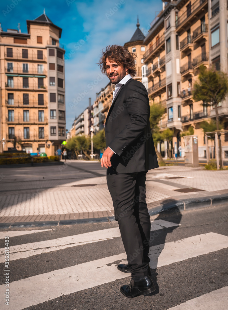 Street style an elegant black suit, white shirt and sunglasses. With a handsome young caucasian man with long hair in the city. Fashion editorial. Crossing a cefras pass Street style an elegant black suit, white shirt and sunglasses. With a handsome young caucasian man with long hair in the city. Fashion editorial. Crossing a cefras pass