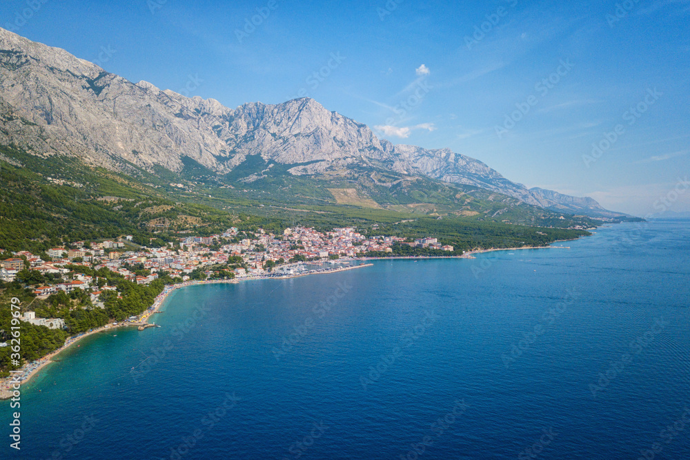 Amazing aerial view of Makarska riviera, Dalmatia, Croatia. Daytime landscape of popular tourist resort on the Adriatic sea coast at the foot of the rocky Dinara mountains, outdoor travel background