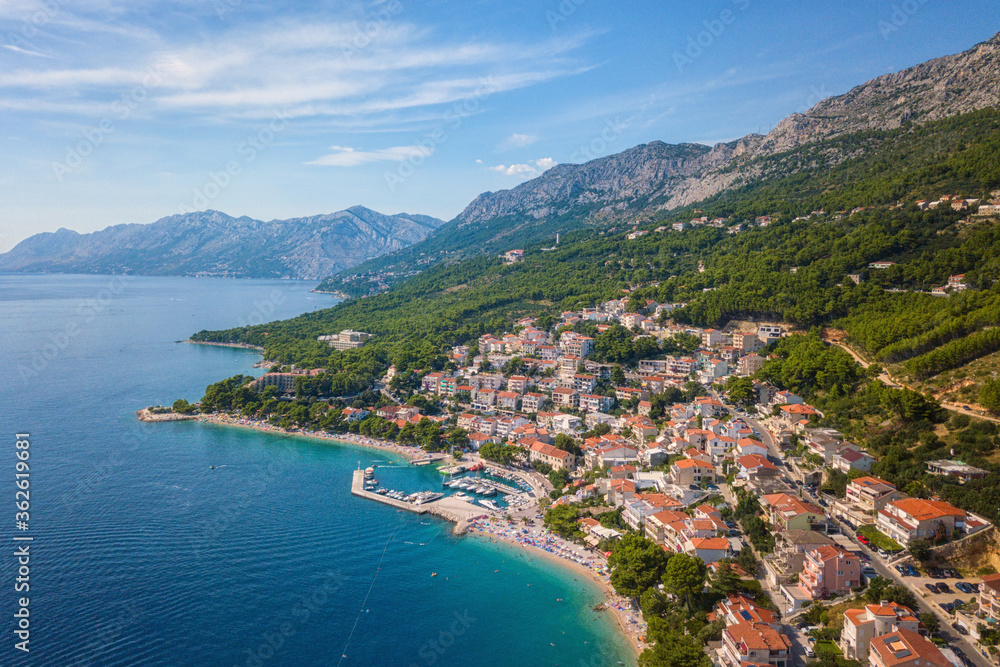 Amazing aerial view of Makarska riviera, Dalmatia, Croatia. Daytime landscape of popular tourist resort on the Adriatic sea coast at the foot of the rocky Dinara mountains, outdoor travel background