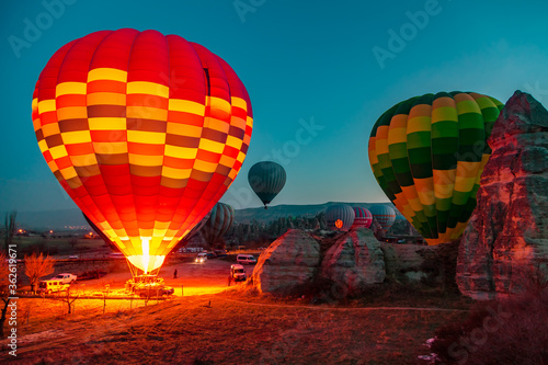 Hot air balloons at sunrise preparing for flight.