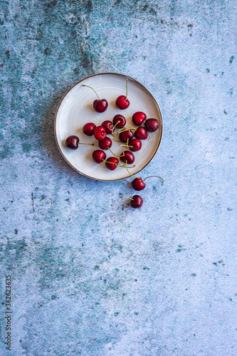 High angle view of freshly picked cherries on a stone surface with copy space