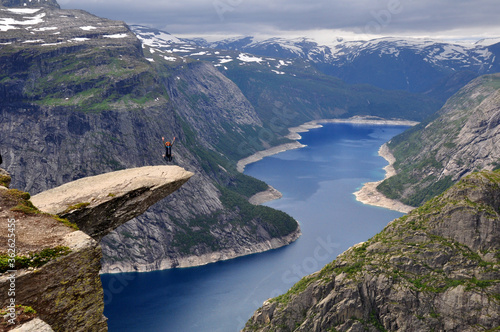 Girl jumping on the rock Trolltunga in Norway
