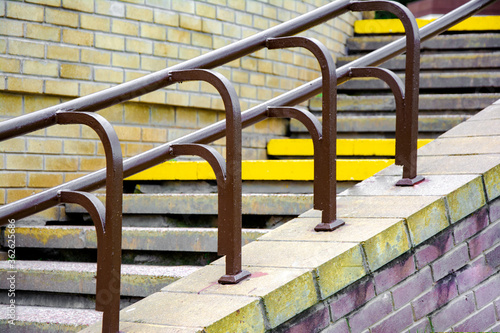 Exterior cement profile of stairs and railings on brick wall background.