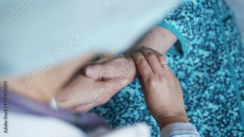 close-up of medic's hands checking pulse in elderly woman, coronavirus infection test photo