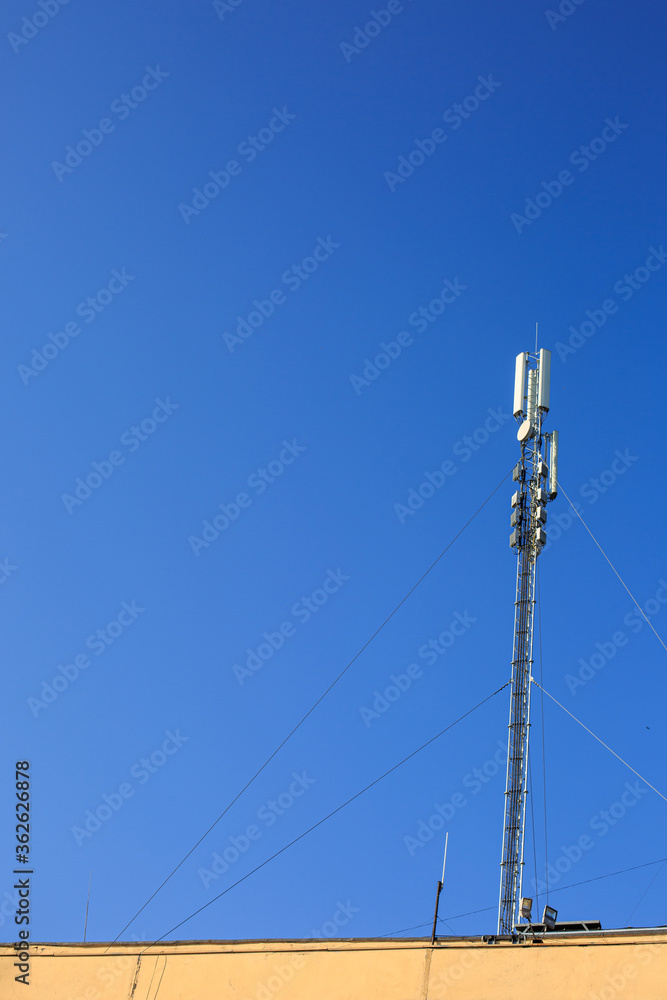 Cellular antenna on the roof on a blue sky background