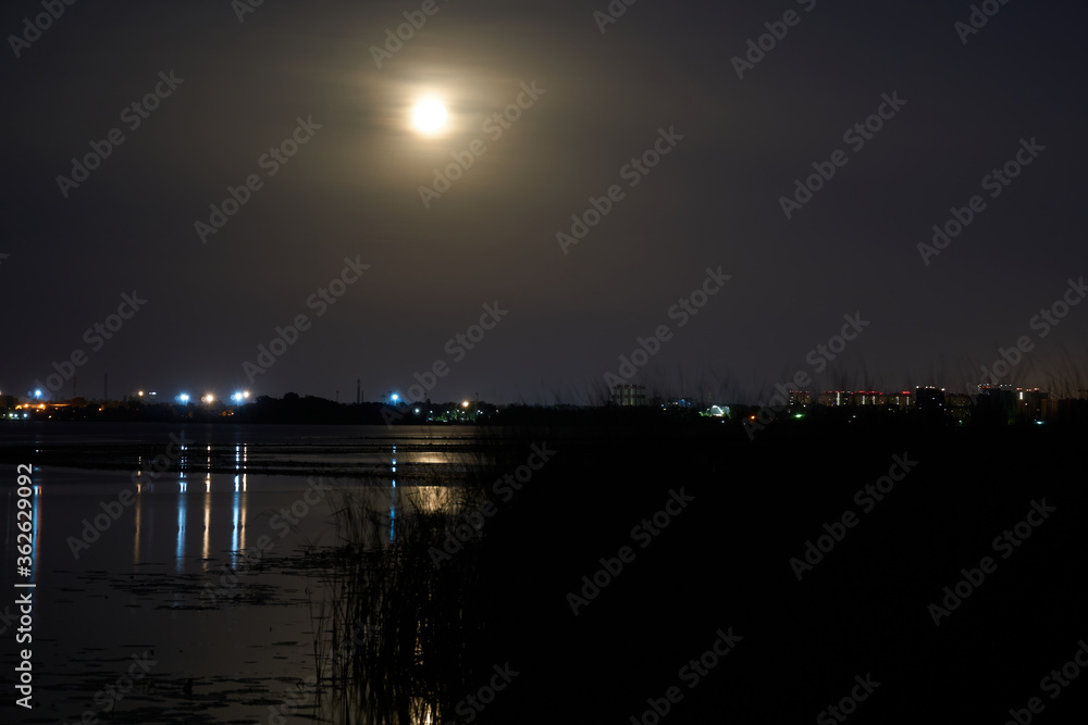 Full moon over a reservoir in the night sky