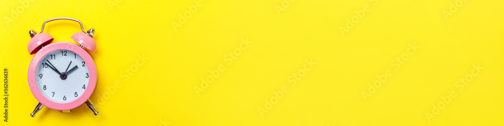 Simply minimal design ringing twin bell classic alarm clock Isolated on yellow background. Rest hours time of life good morning night wake up awake concept. Flat lay top view copy space banner - obrazy, fototapety, plakaty 
