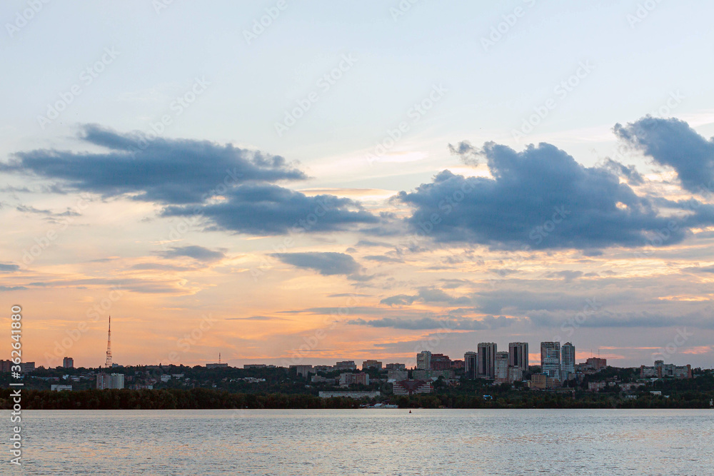 View of the downtown and river at sunset. Colorful sky with clouds. Cityscape, background