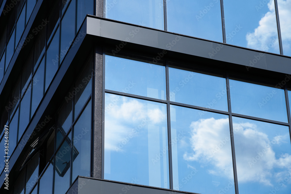 facade of a modern building on a bright Sunny day, blue sky and clouds reflecting in a glass, beautiful exterior of the new building facade of a modern building on a bright Sunny day, blue sky and clouds reflecting in a glass, beautiful exterior of the new building