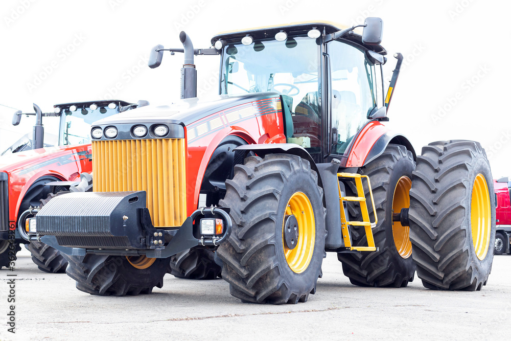 Large agricultural tractor on a white background. Equipment for cultivating the land. Close-up. Large agricultural tractor on a white background. Equipment for cultivating the land. Close-up.