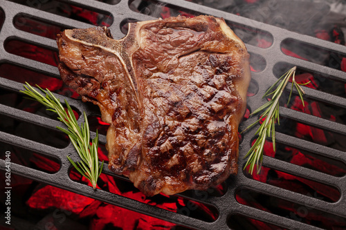 Fotografie T-bone beef steak cooking on grill