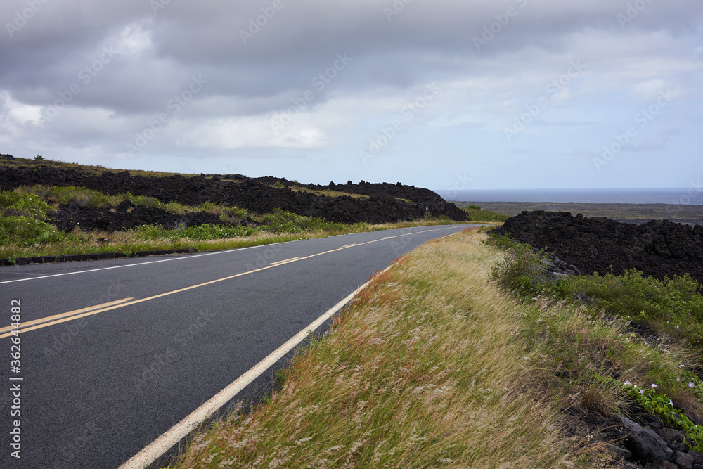 Chain of Craters Road in Hawaii Volcanoes Nation Park with the Pacific Ocean in the near distance as the sky gradually clears up.