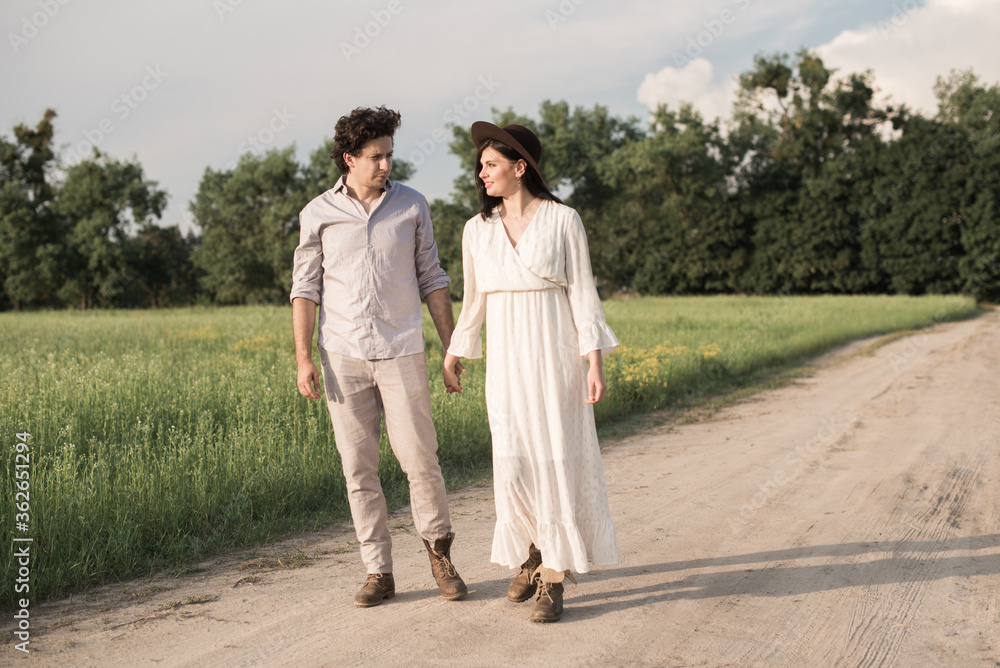Young couple walking together hand by hand in countryside Young couple walking together hand by hand in countryside