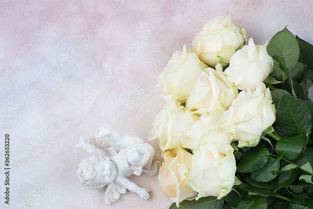 a bouquet of white roses and a white angel figurine