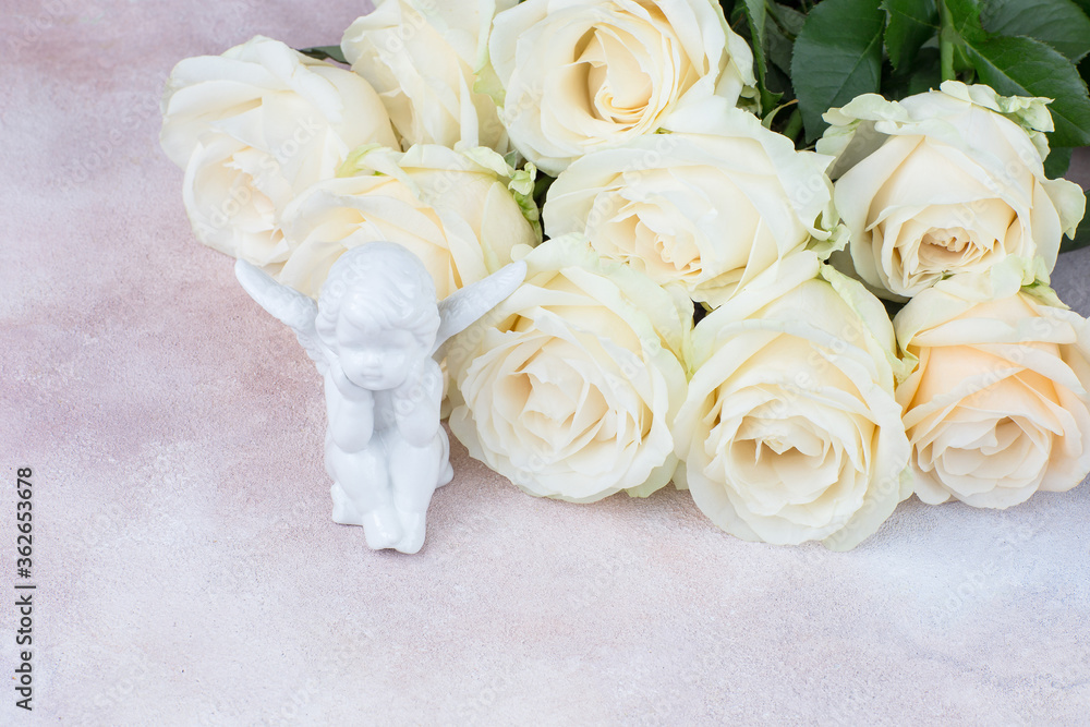 closeup white roses bouquet and white angel figurine