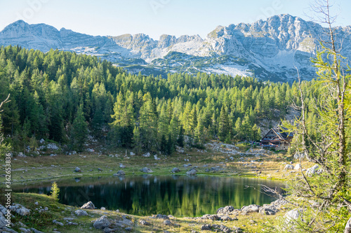 Stunning view of a picturesque lake and cottage in the heart of Julian Alps.