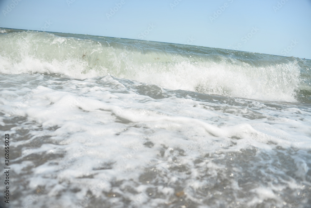 during the day the sea waves and splashes of small drops fall on the shore during the day the sea waves and splashes of small drops fall on the shore