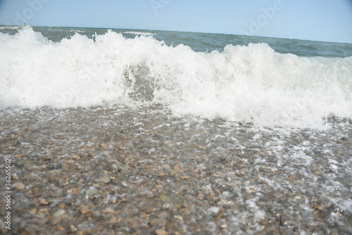 Fototapeta Naklejka Na Ścianę i Meble -  during the day the sea waves and splashes of small drops fall on the shore