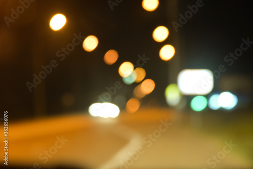lights from headlights of cars and lights from the street lamps draw a colored track in the dark