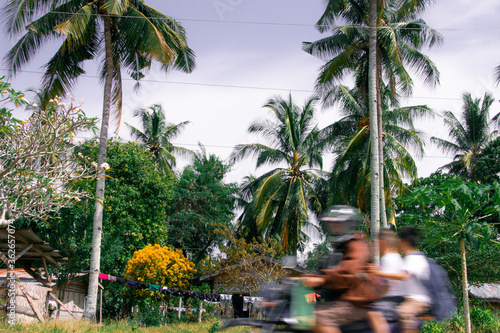 A family of three race home on a motorcycle on Samal Island photo