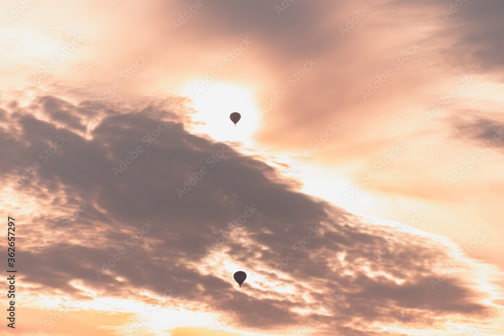 Two balloons on a background of pink sunset and clouds