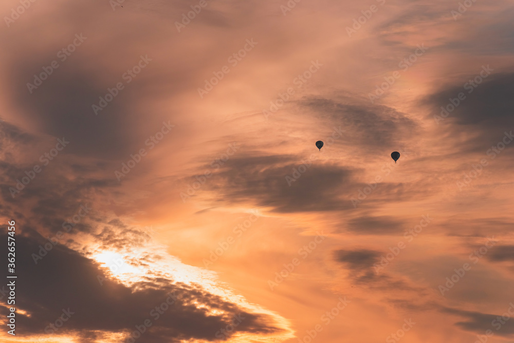 Two balloons on a background of pink sunset and clouds