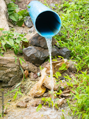 Waste water flowing from blue pipe background