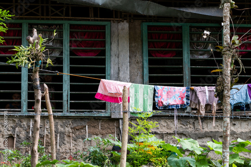 Colorful clothing hanging from a clothes line surrounded by nature photo